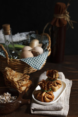 two bags of thin pancakes with mushroom filling, a stack of pancakes and a basket with eggs close-up on a dark 