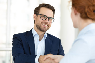 Close up smiling man handshaking with boss at meeting.