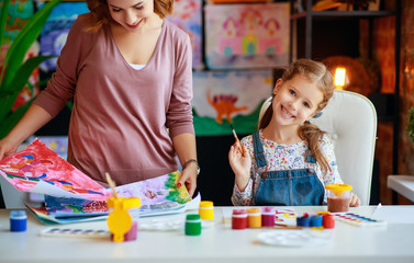 mother and child daughter painting draws in creativity in kindergarten.