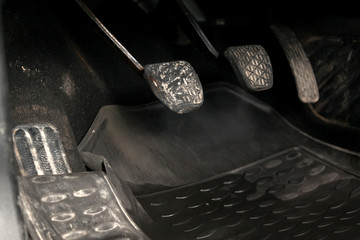 Old retro gas pedals and brakes in a car with mechanical gear on the floor with a rubber mat. The...