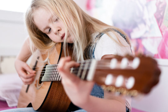 Generation Z - a teenager girl plays the guitar in her room.