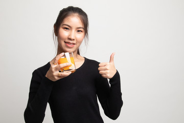 Young Asian woman thumbs up drink orange juice.