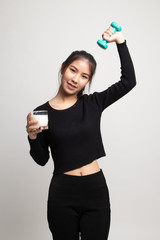 Healthy Asian woman drinking a glass of milk and dumbbell.