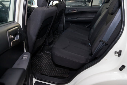 Close-up Aon Rear Seats With Velours Fabric Upholstery In The Interior Of An Korean Car In Black After Dry Cleaning With Floor Mat Carpets. Auto Service Industry.