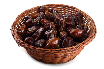 Date fruits on wicked plate isolated on white