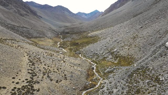An aerial view inside Andes mountains at Limari Valley, south Atacama. An amazing wild scenery. Arid idyllic valleys with green farm fields feed in by the river at the bottom of the valley

