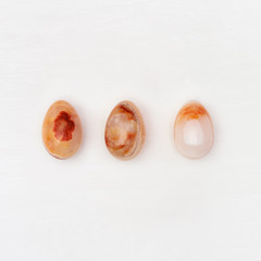 Decorative Easter eggs made from Natural gemstone onyx. Minimal flat lay background with copy space.