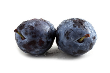 Black plums isolated on white