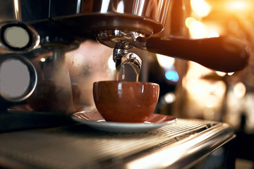 modern black espresso making machine brewing coffee, close up side view photo