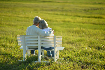Senior woman and man sitting on bench