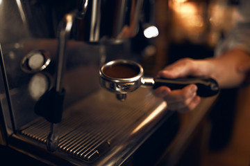 Fototapeta na wymiar Portafilter with scattered ground coffee.guy making espresso , close up photo