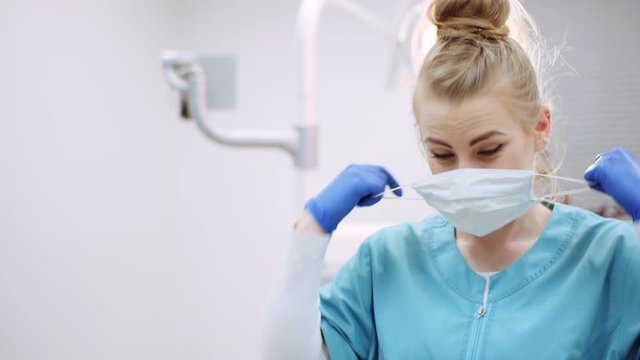 dentist putting on protective mask before surgery