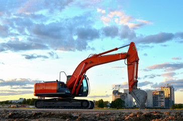 Fototapeta na wymiar Large tracked excavator on a construction site background of the awesome sunset. Road repair, asphalt replacement. Backhoe the digging pipeline ditch. Commercial and Public Civil Work Contracting