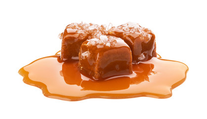Salted toffee candies with caramel sauce isolated on white background - obrazy, fototapety, plakaty