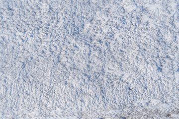 Background with a snowy surface with snow-covered vegetation taken from a height