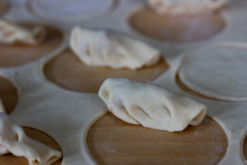 Dough rolled out in a pattern for preparation of ravioli or pelmeni. The rolled out dough. Rolled into a sausage dough. Flour dough for dumplings. Cooking dumplings