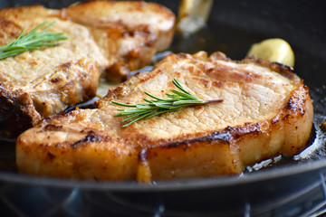 Pork chop on a frying pan. Selective focus. Concept for the ketogenic food. 