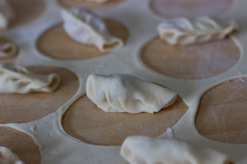 Dough rolled out in a pattern for preparation of ravioli or pelmeni. The rolled out dough. Rolled into a sausage dough. Flour dough for dumplings. Cooking dumplings