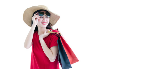 Portrait of an excited beautiful asian girl wearing dress and sunglasses holding shopping bags isolated over bright blue white background. Happy on big sale, flash sale, black friday