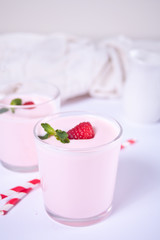 Two portions natural homemade yogurt in a glass jar with fresh raspberry. Breakfast concept.