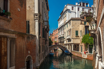 Fototapeta na wymiar View of narrow Canal with boats and gondolas in Venice, Italy
