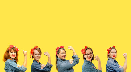 Women with a clenched fist rolling up their sleeves on yellow background, copy space, tribute to the icon Rosie Riveter. Girl power concept. Women's day.