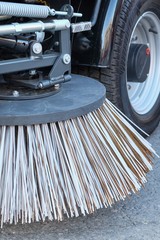 Sweeping equipment for routine year-round municipal street and highway sweeping.Big round broom of street sweeper with wide sweeping path close up. Urban street cleaning.All seasons cleaning machine.