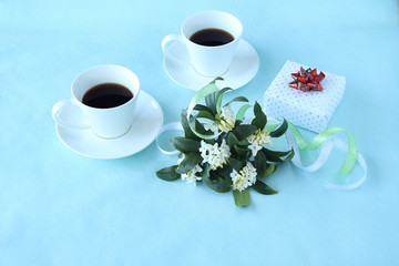 Obraz na płótnie Canvas プレゼントと白い沈丁花のアレンジメントとコーヒー