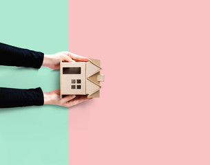 Woman holding a cardboard house overhead view