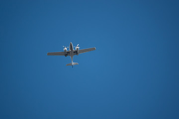 a small twin-engined aircraft has extended its landing gear for landing