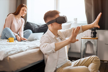 young man wearing VR glasses having adventure, adventurous man having fun with virtual goggles. cutting edge technology.