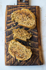 Homemade bread slices with flax, sunflower whole seeds on wooden board. Vegan and vegetarian healthy food.
