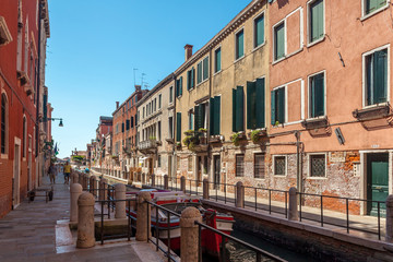 View of narrow Canal with boats and gondolas in Venice, Italy