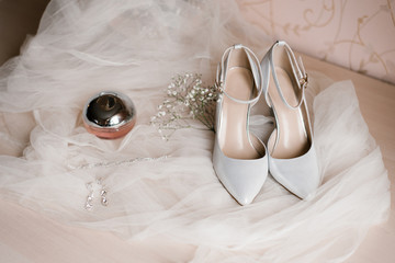 Ladies ' accessories: grey shoes, eau de toilette, costume jewelry and a sprig of gypsophila on a...