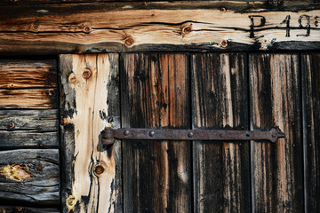 holz detail einer verwitterten türe mit eisen türbeschlag von schuppen in den alpen 