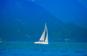 Fototapeta premium Sailboat in the lake Lucerne, Switzerland When the sky is bright, white clouds