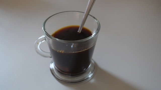 UNE PIERRE DE SUCRE TOMBANT AU RALENTI DANS UNE TASSE DE CAF&Eacute;