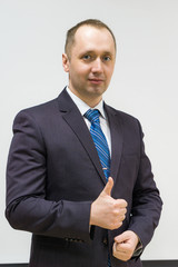 portrait of a confident, purposeful, successful businessman weared in grey suit and blue neck tie