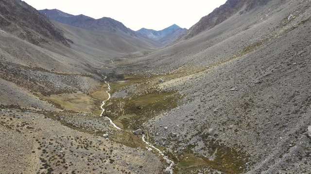 An aerial view inside Andes mountains at Limari Valley, south Atacama. An amazing wild scenery. Arid idyllic valleys with green farm fields feed in by the river at the bottom of the valley

