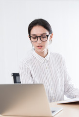 A businesswoman wearing glasses working with smiling and happiness at the office.