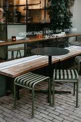 Restaurant with empty window for mockup, logo or text promotion. A small table with chairs near the cozy cafe. Modern cafe interior.