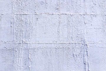 A crop of a cement wall that portrays a rough textured