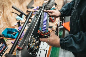 Man repairing electrical scooter in special workshop. © hedgehog94