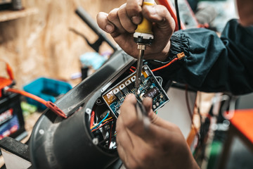 Fototapeta na wymiar Man repairing electrical scooter in special workshop.