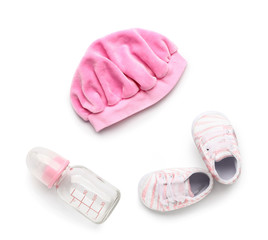 Obraz premium Baby hat with booties and bottle on white background