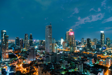 Fototapeta na wymiar Aerial cityscape of picturesque Bangkok at night time from rooftop. Panoramic evening skyline of the biggest city in Thailand. The concept of metropolis.