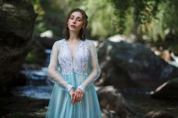 The Tale of the Mermaid. Tale of the River Nymph. Girl in a blue dress by the river.