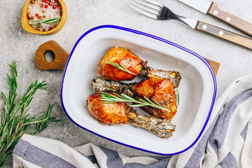 Grilled chicken drumstick bbq with rosemary on a stone gray background.