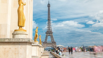 Fototapeta na wymiar Eiffel Tower and the golden statues of women in the sun light timelapse, Trocadero square, Paris, France