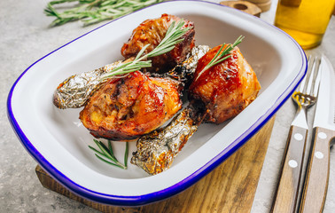 Grilled chicken drumstick bbq with rosemary on a stone gray background.